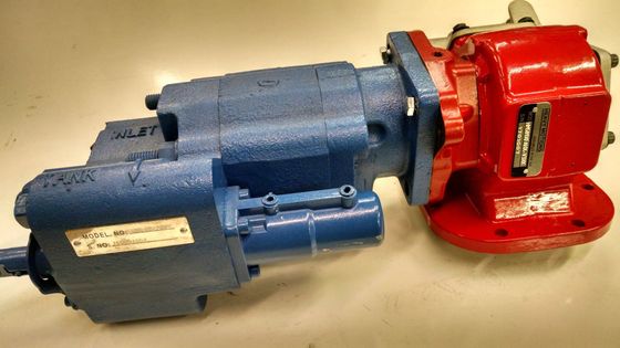 Blue-and-red industrial hydraulic tool lying on a beige surface