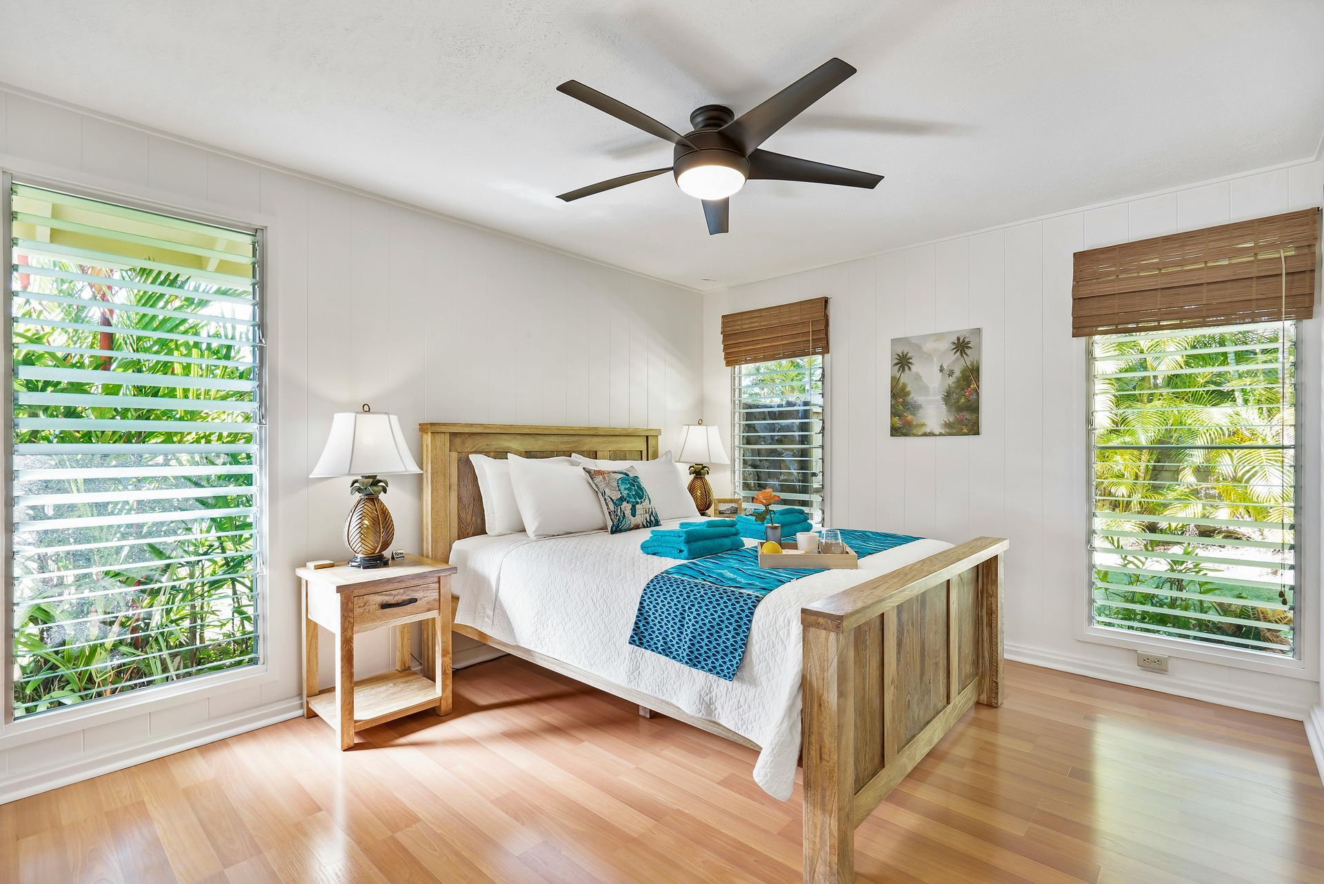 Large white ceiling fan with six blades, mounted in a red metal-framed building.