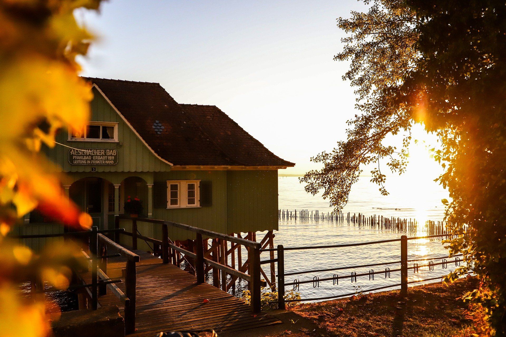 Sage green home on lake at sunset