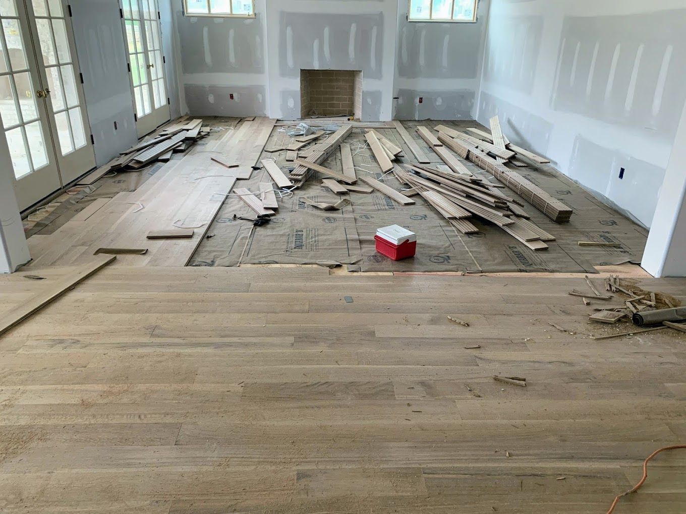 A living room with hardwood floors and a fireplace under construction.