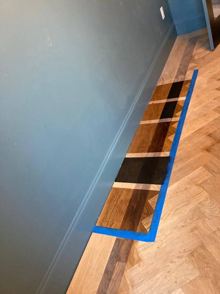 A wooden floor with a blue tape around it.