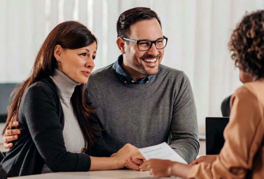 a man and a woman are sitting at a table talking to a woman