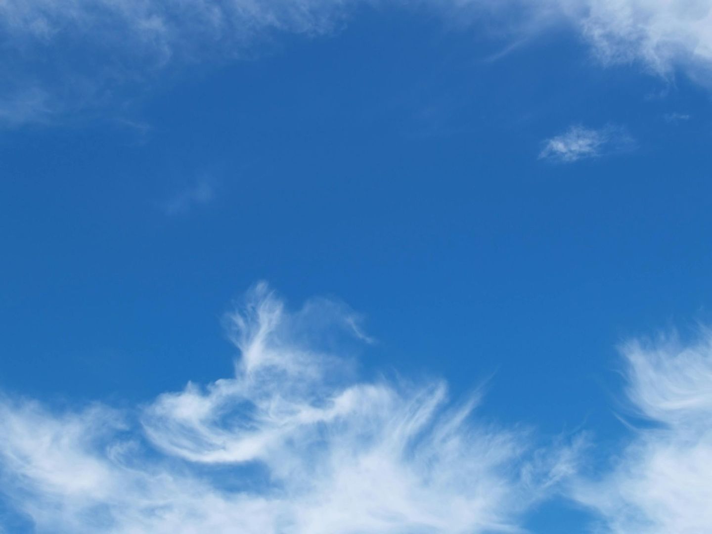 Blue sky with wispy white clouds.