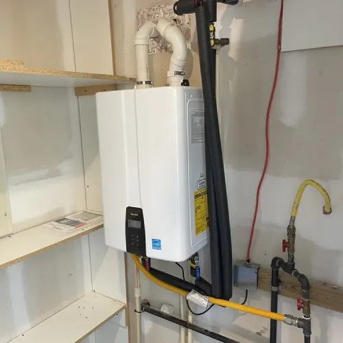 A white water heater is mounted to the wall in a room | The Duke Of Plumbing