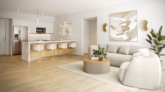 Bright open-concept living room with white sofa, round coffee table, and kitchen island with stools