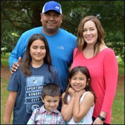 a family is posing for a picture together in a park .