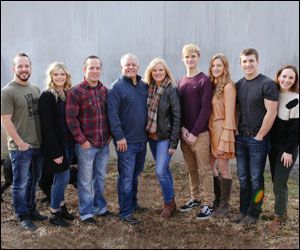 a large family is posing for a picture together in front of a wall .