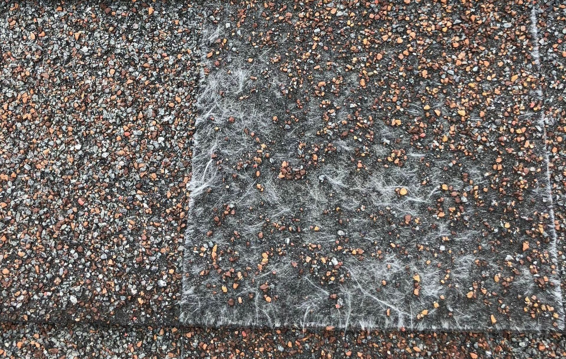 a close up of a roof with a lot of small stones on it .