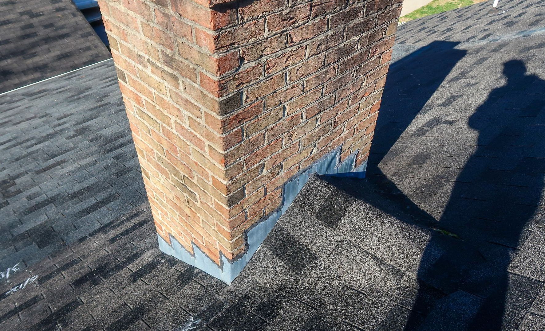 a brick chimney is sitting on top of a roof .