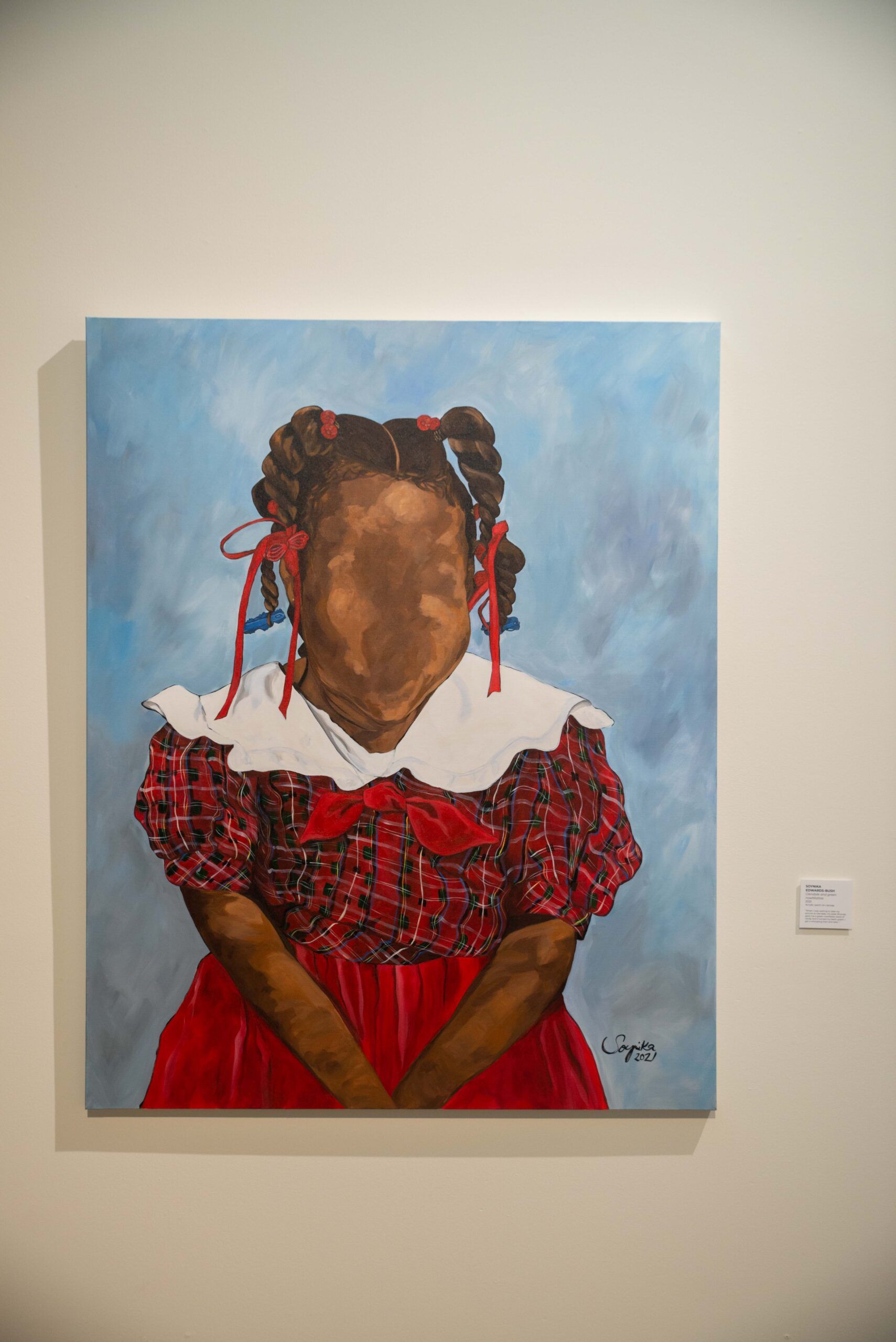 Portrait painting of a child in a red plaid dress with braided ribbons against a blue background