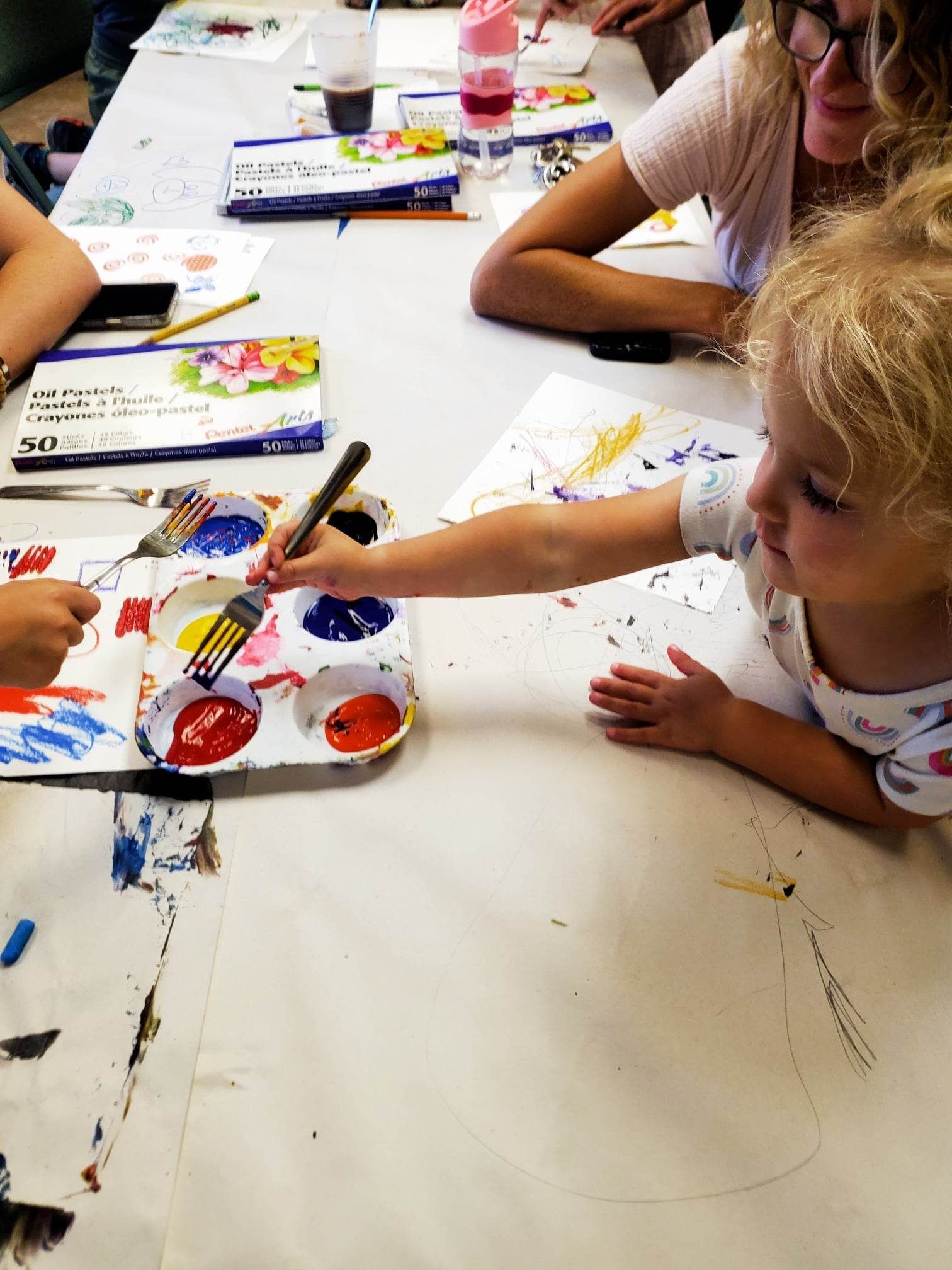 Children painting with bright colors at a table in an art class