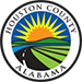 Houston County Alabama seal with a sunburst, green fields, and road winding through a landscape.