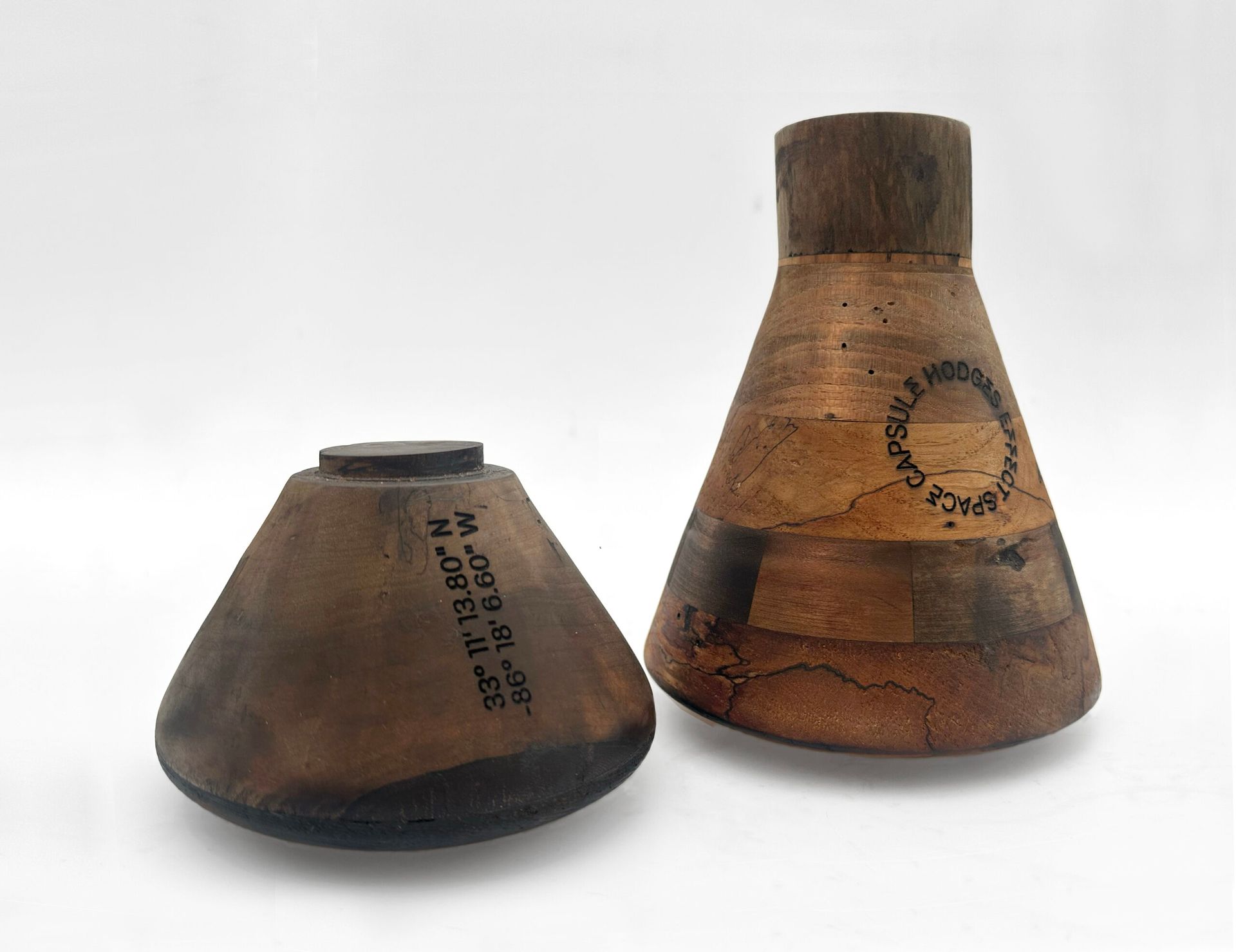 Two brown leather shoe lasts, one conical and one tapered, on a white background