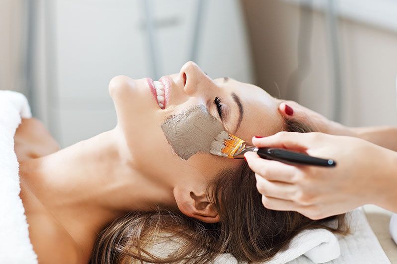 A woman is getting a facial treatment at a spa.
