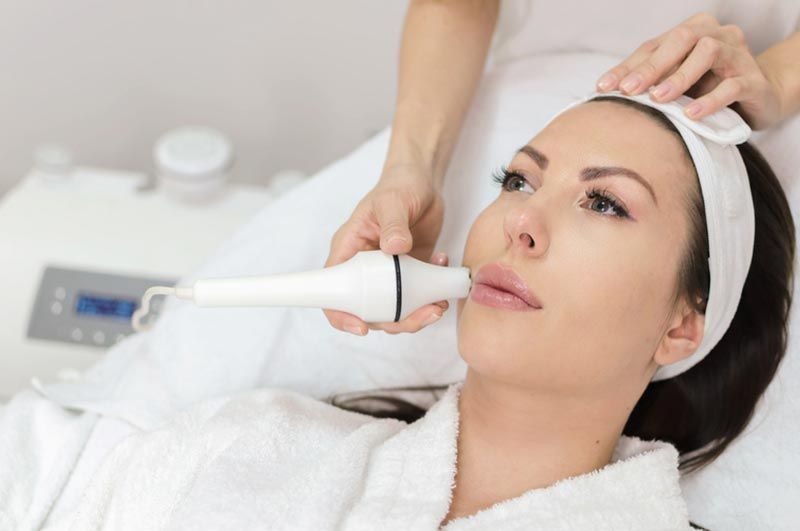 A woman is getting a facial treatment at a beauty salon.