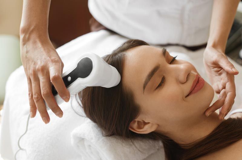 A woman is getting a head massage at a spa.