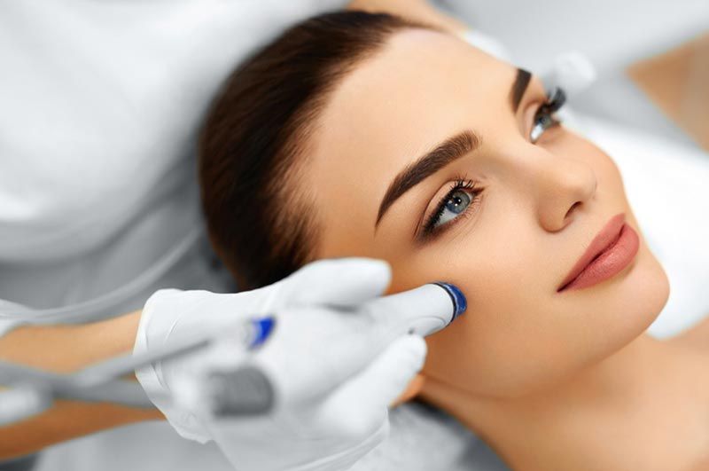 A woman is getting a facial treatment at a beauty salon.
