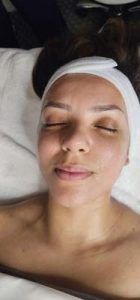 A woman is laying on a bed with her eyes closed and a headband on her head.