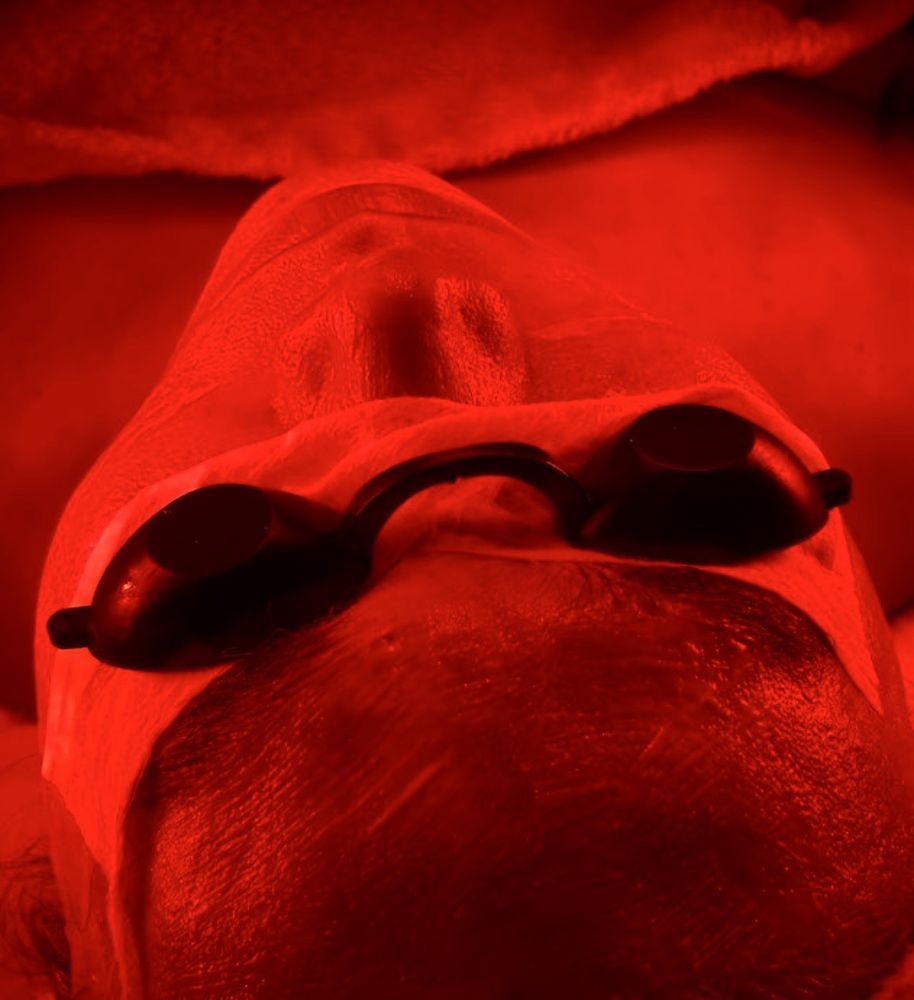 A close up of a person wearing red light glasses.