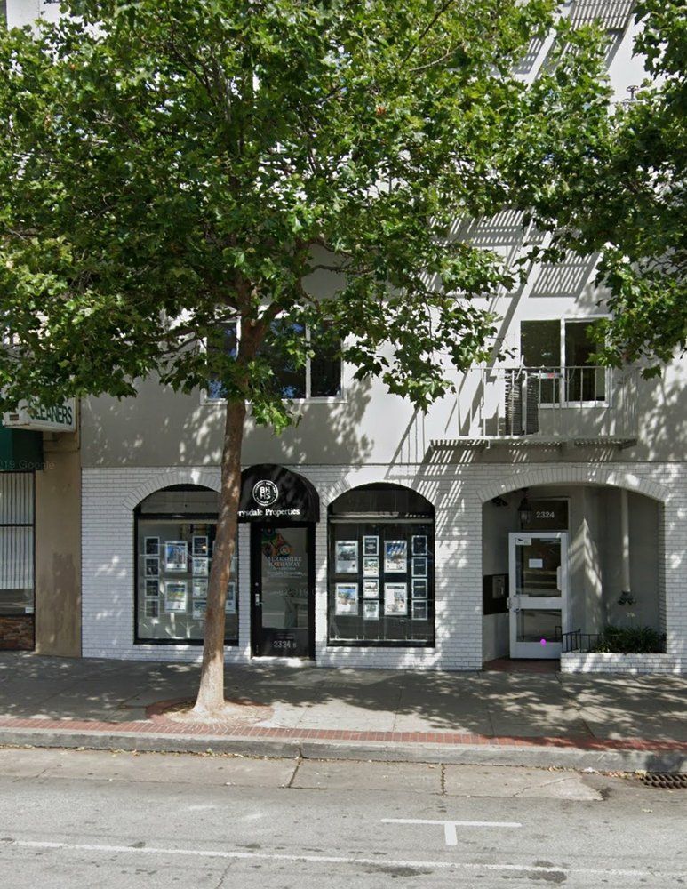 A building with a tree in front of it and a sign that says ' a ' on it