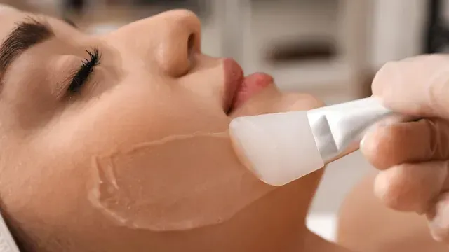A woman is getting a facial treatment at a beauty salon.