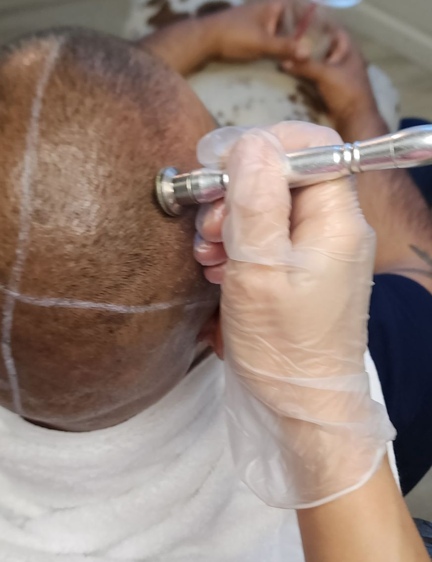 A woman wearing a mask and gloves is getting a tattoo