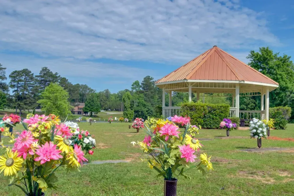 Flower-filled garden with a gazebo under a blue sky