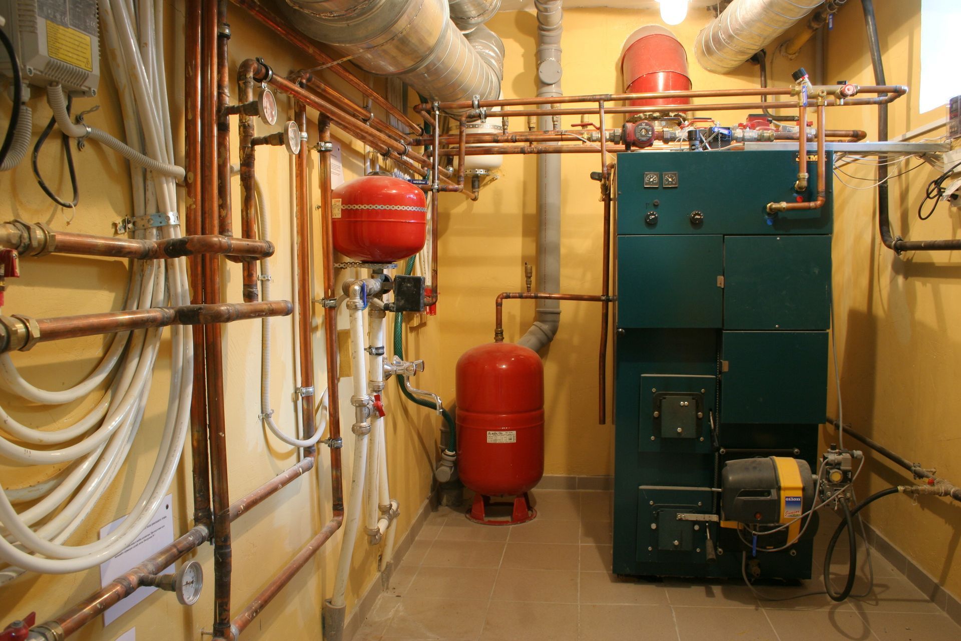 A room with a boiler and a lot of pipes.