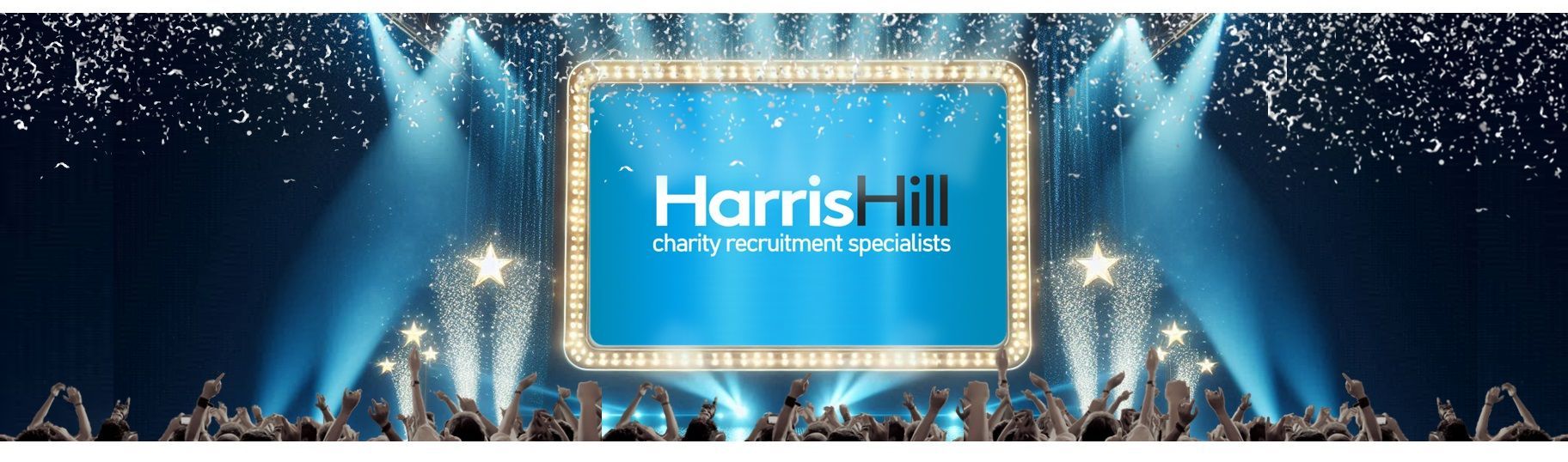 A marquee with the Harris Hill logo on a stage with a cheering crowd, lights, and confetti.