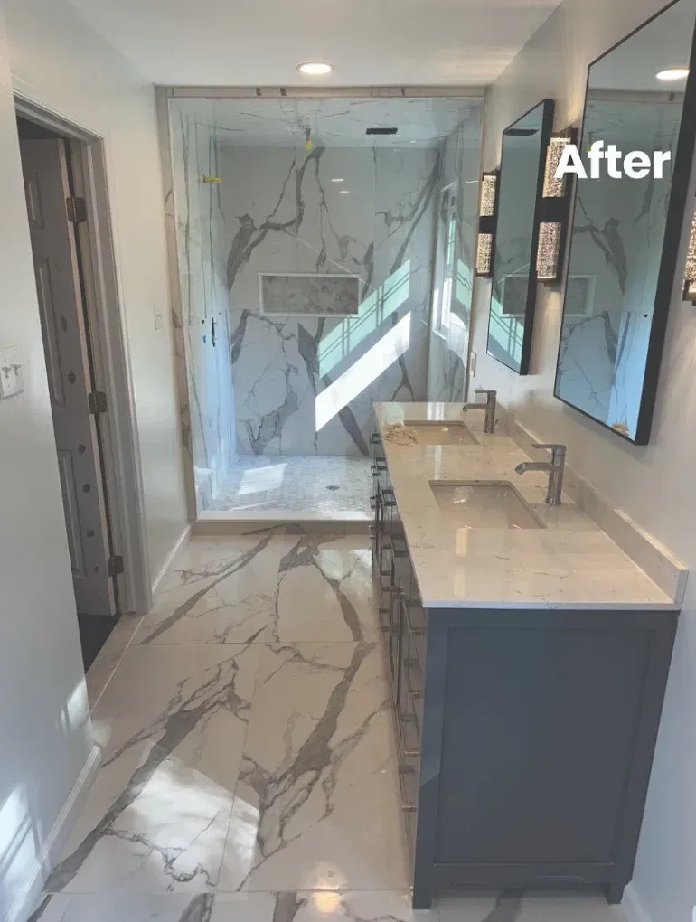 Bathroom renovation. Modern design: marble shower, double vanity, grey cabinets, large mirrors, white floors.
