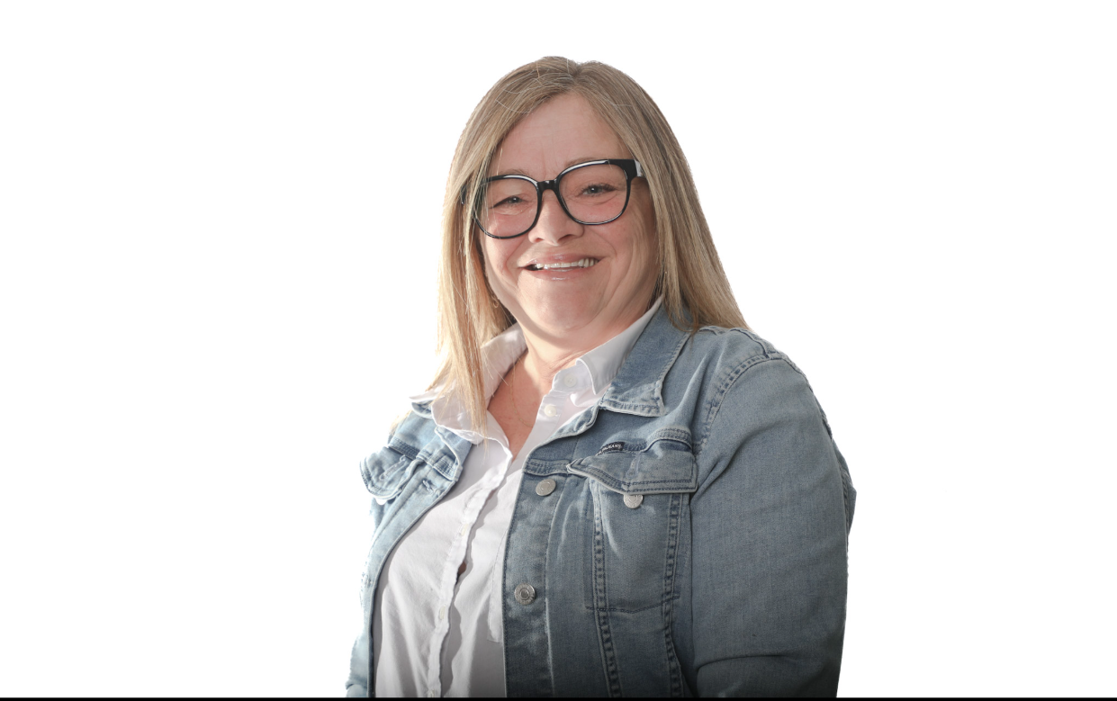 Personne souriante portant des lunettes et une veste en jean sur fond blanc