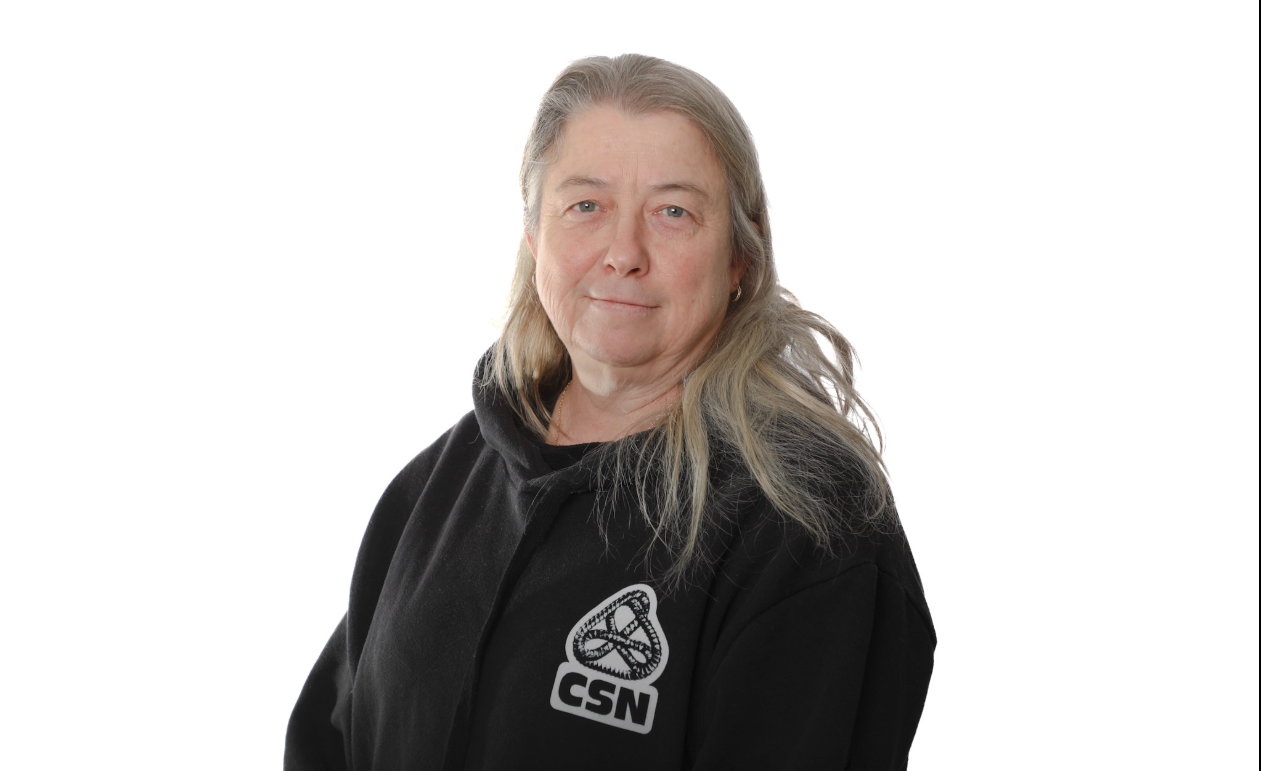 Personne portant un sweat à capuche noir avec le logo CSN, se détachant sur un fond blanc.