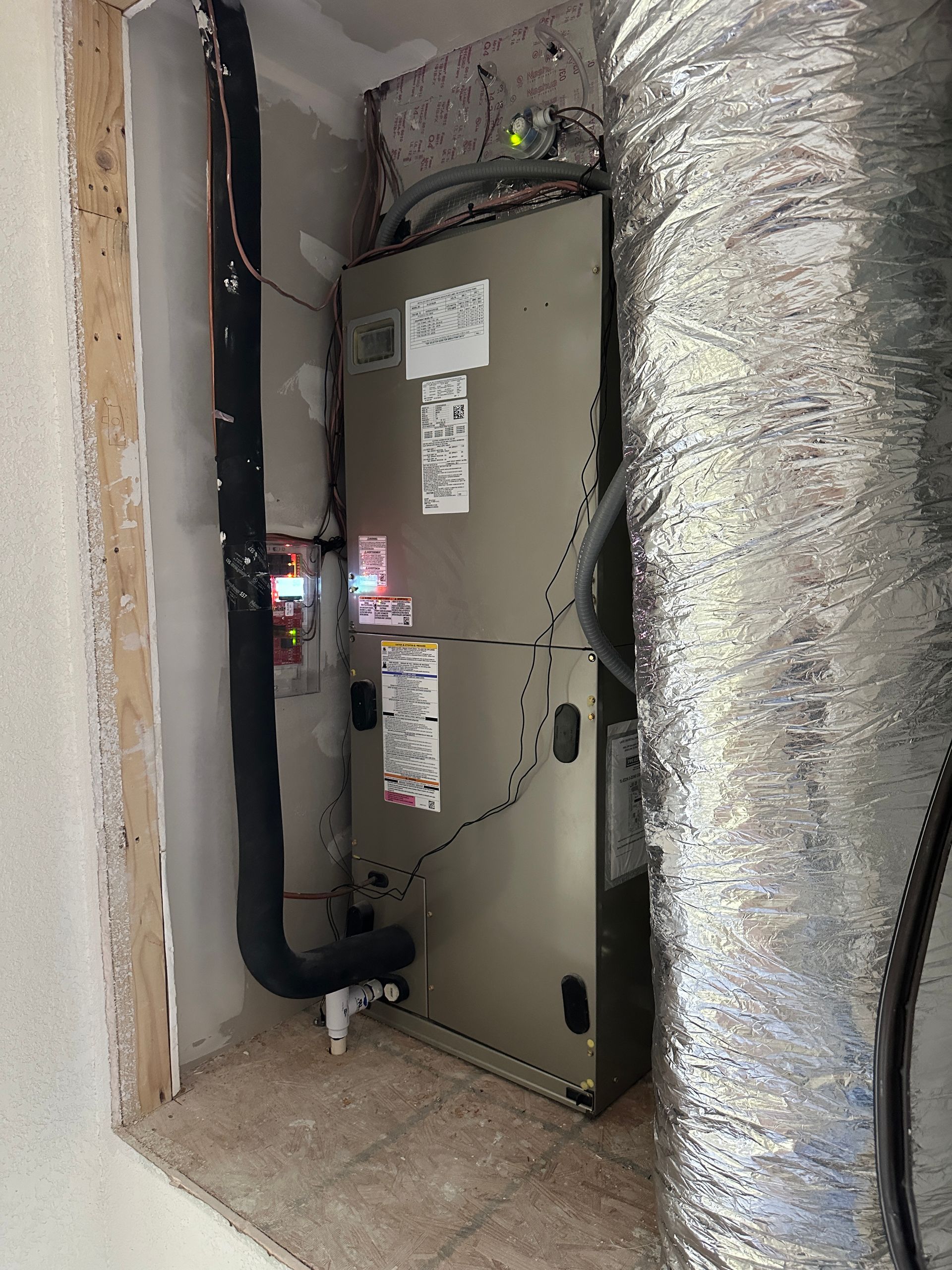 HVAC unit inside a utility closet, with insulated ductwork.