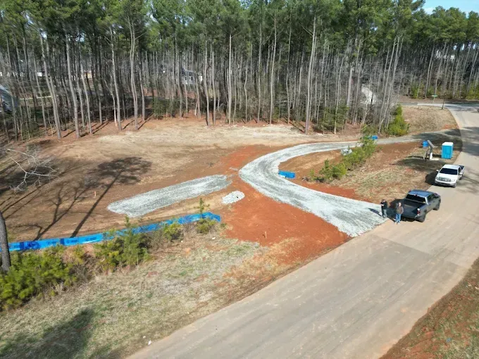 Gravel access drive through a cleared wooded property