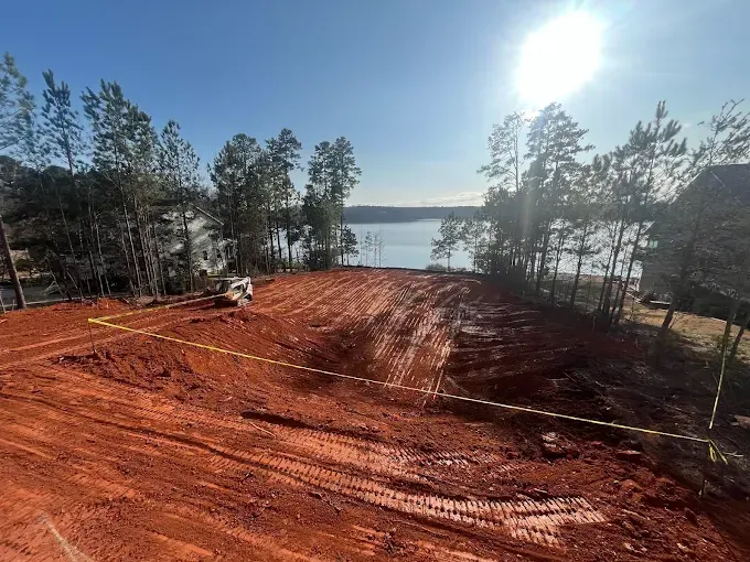 Excavated red-soil site overlooking a lake