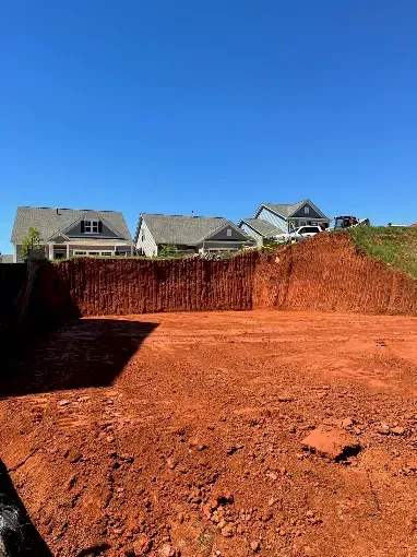 Excavated building area beside residential homes
