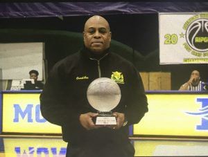 A man holding a trophy in front of a sign that says ripg