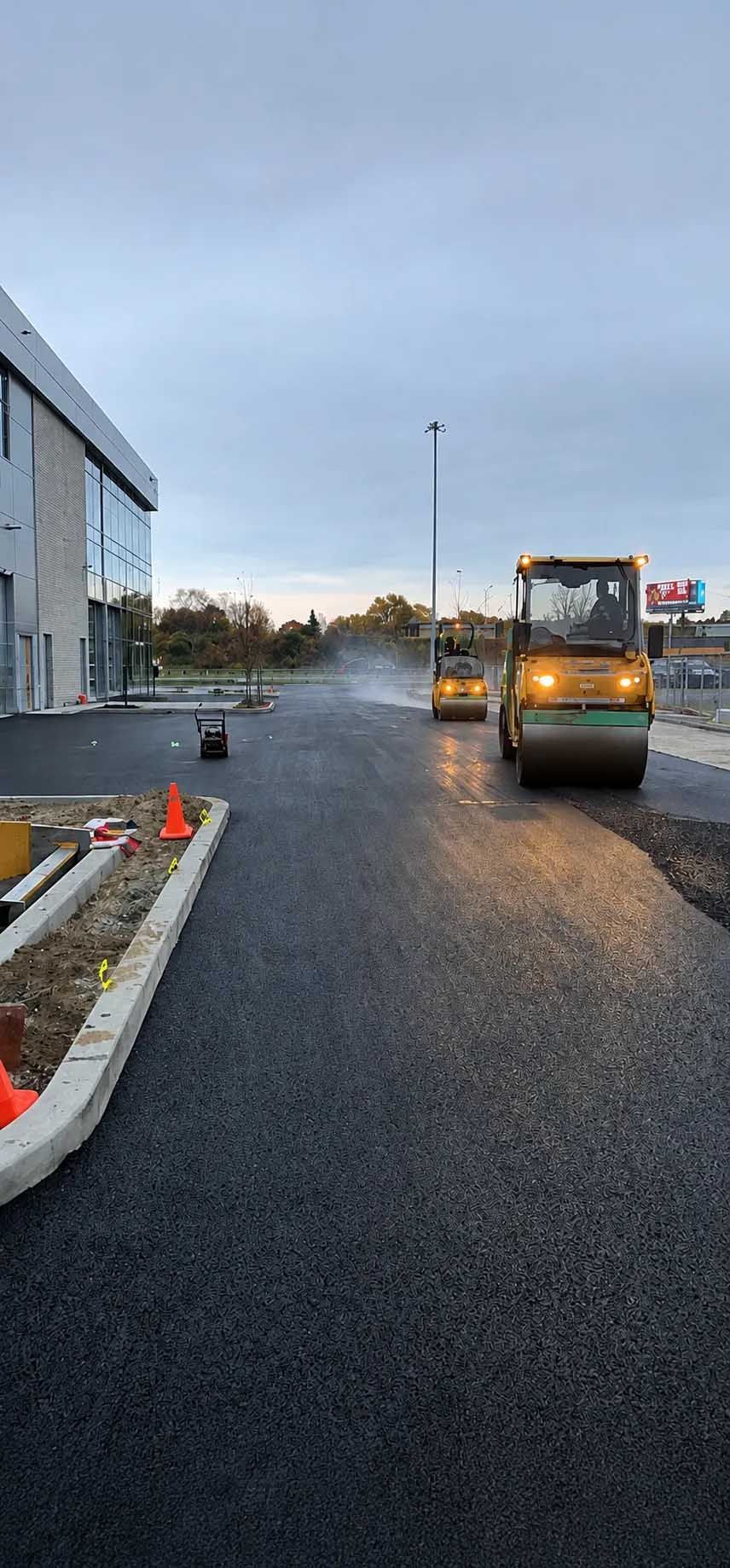 Camion-benne sur une route mouillée à côté d'un bâtiment industriel au crépuscule