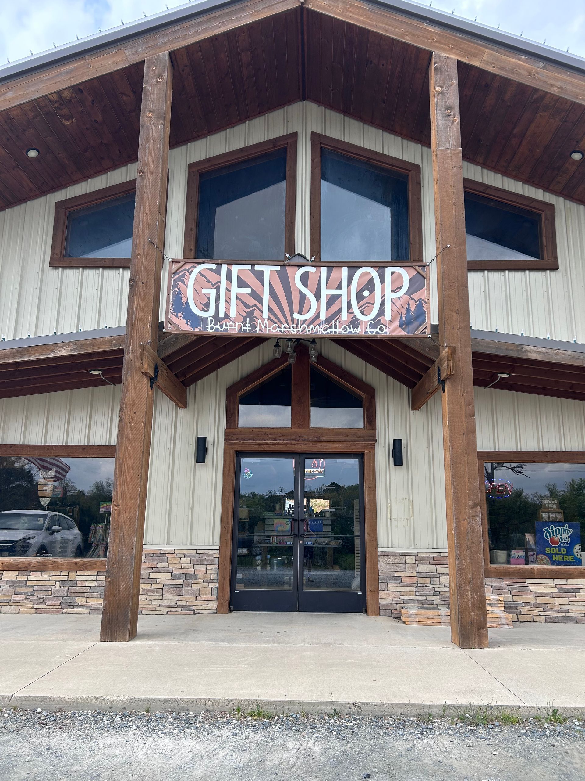 Front entrance of a rustic gift shop with large windows and wooden beams