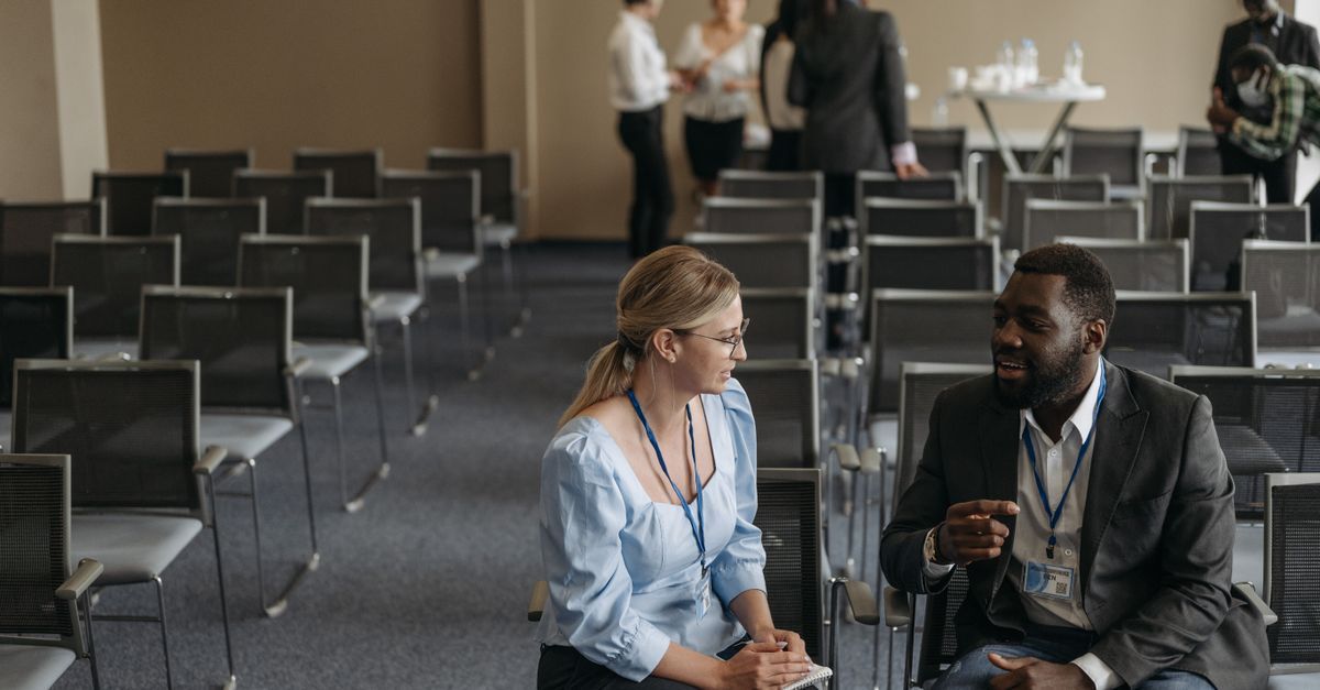 Profesionales conversando en un auditorio antes de una conferencia