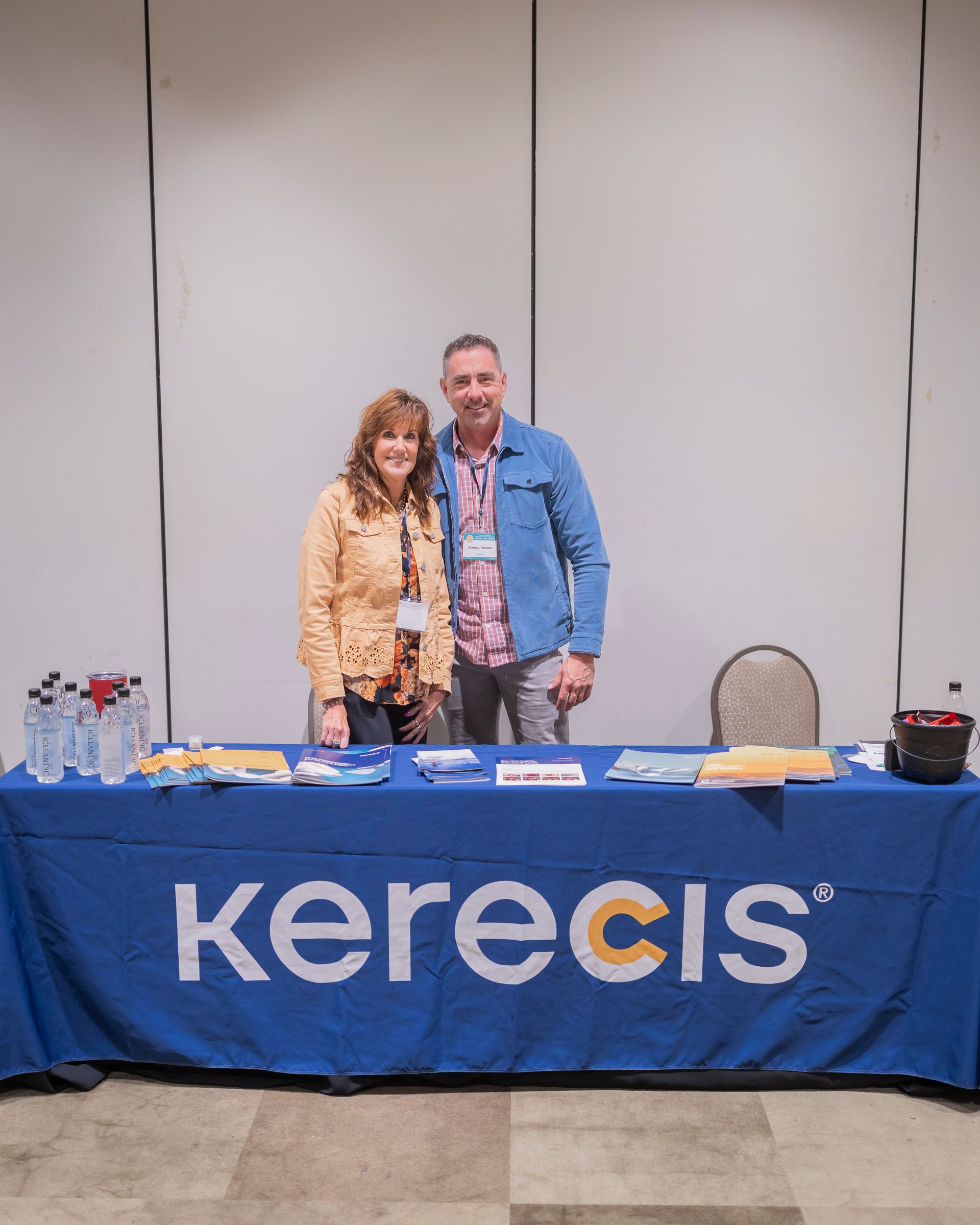 Two people standing behind a blue Kerecis table at a conference booth