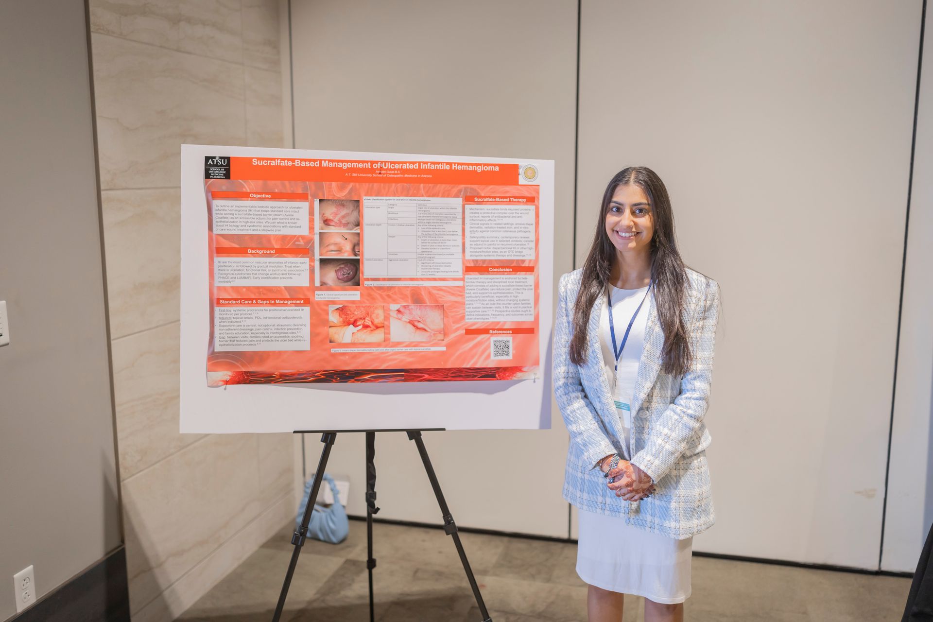 Woman standing beside an orange poster board on an easel in a conference room
