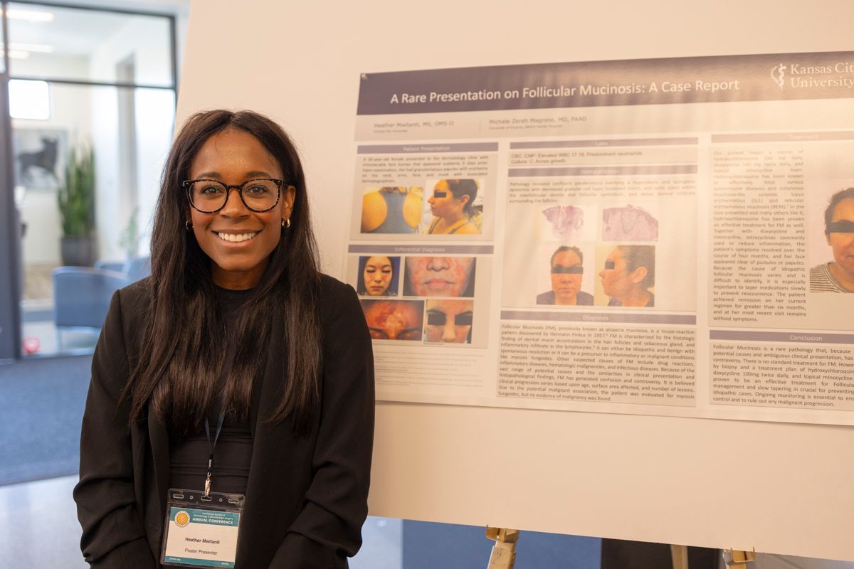 Woman stands in front of her poster presentation at KSDDS Annual Conference