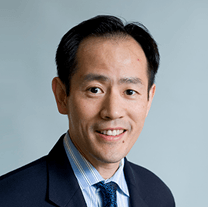 A man in a suit and tie is smiling for the camera.