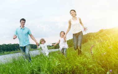 Parents and Child Running Free on Field — Portage, MI — Cornerstone Chiropractic Center