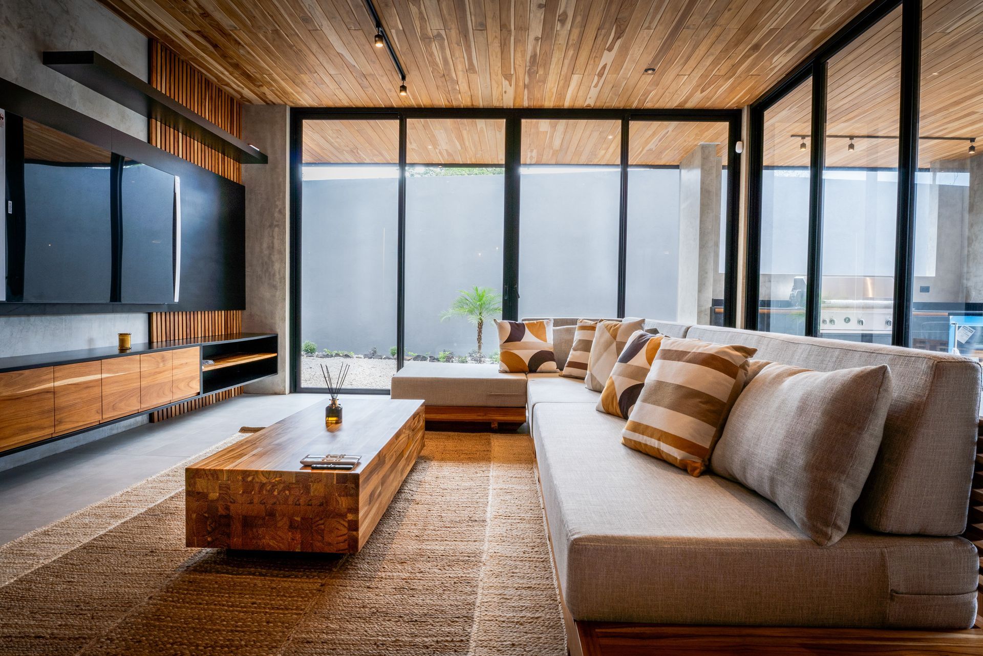 Modern living room with wood accents, large windows, and sectional sofa.