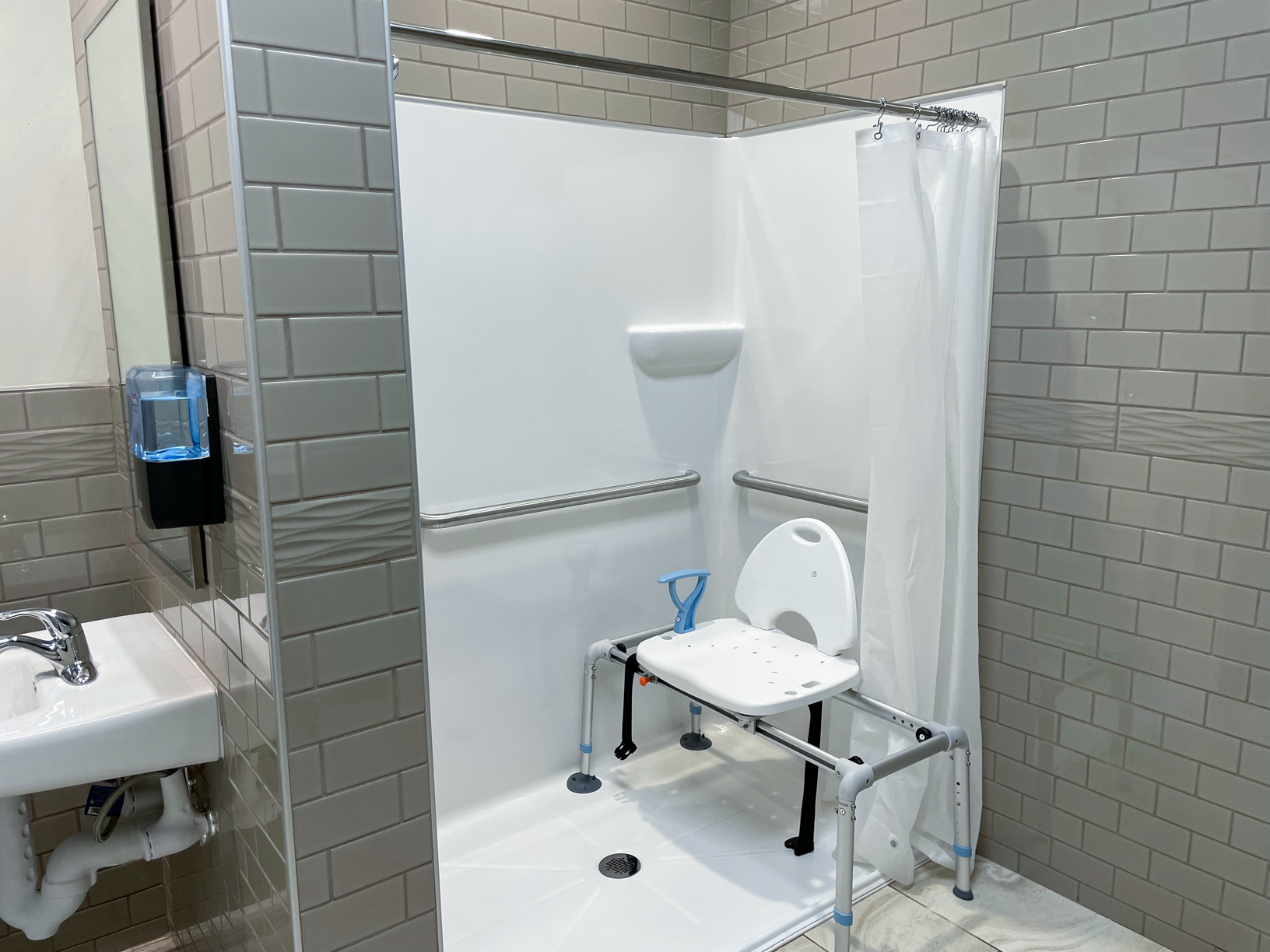 Modern walk-in shower equipped with a shower chair for accessibility and comfort.
