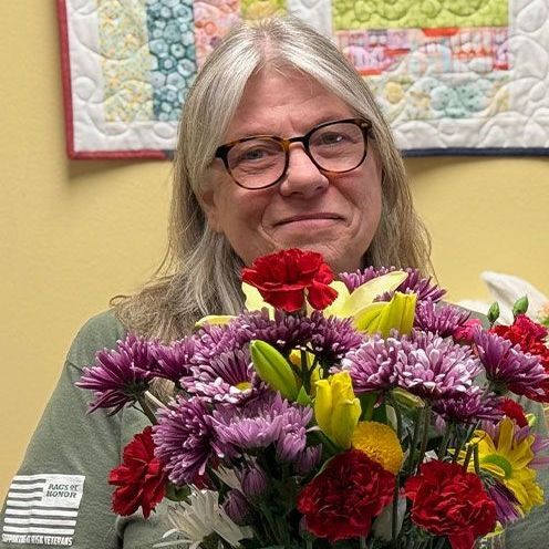 Bluegrass Care Navigators volunteer Cathy Betzner-Sutton with bouquet of flowers