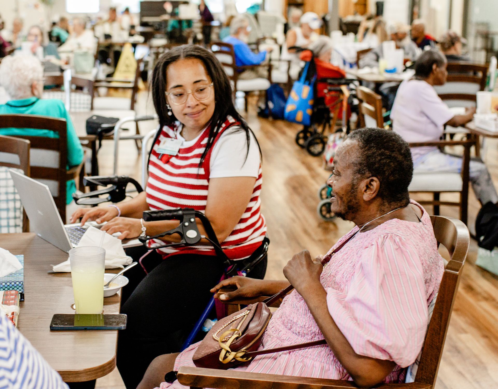 PACE director helps a woman complete the PACE enrollment process.
