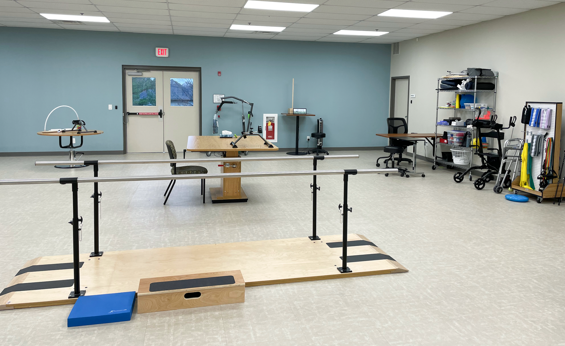 Physical therapy gym with parallel bars used to support walking and mobility training.